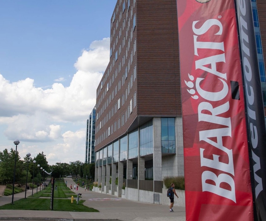 dorm building in the background with a sign reading 'bearcats in the foreground