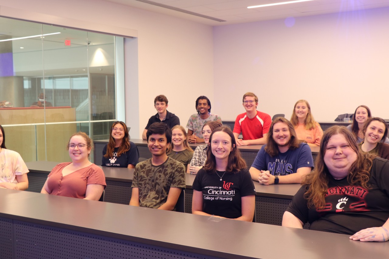 A group of resident advisors all pointing to a woman in the middle with a hashtag sign.